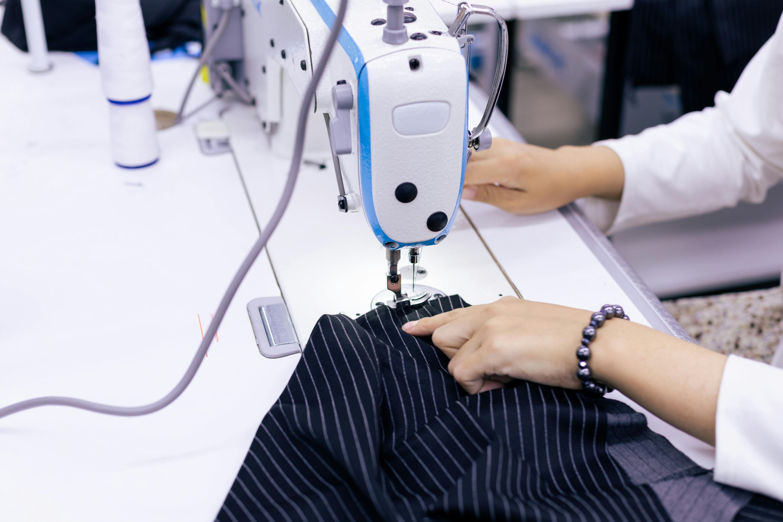 A designer inspecting a garment sample with a magnifying glass.