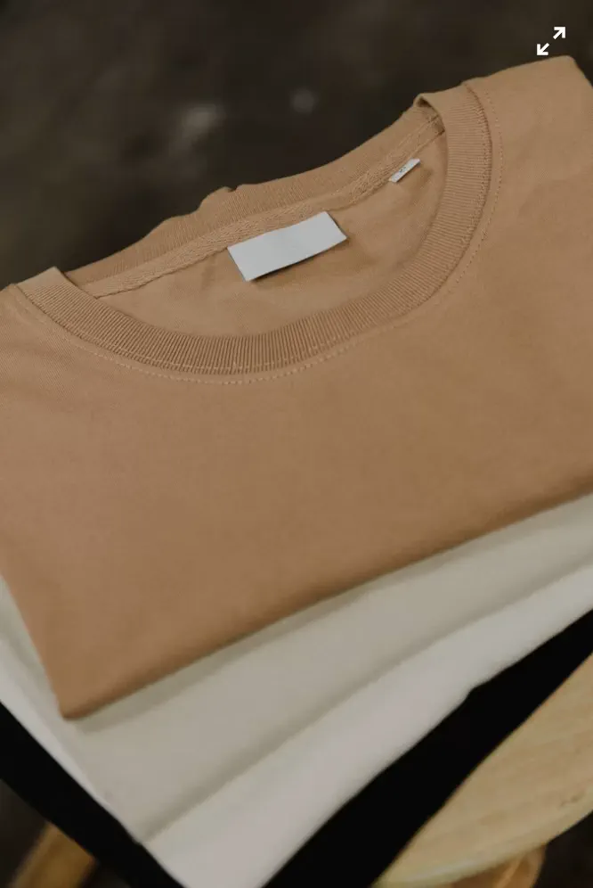 リブ付きクルーネックとブランドタグを備えた無地コットンTシャツ。OEM生産の参考