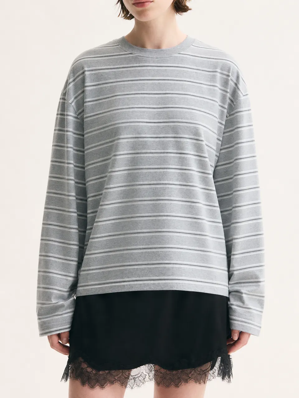 レーススカートと合わせたグレーストライプのリラックスフィット長袖Tシャツ