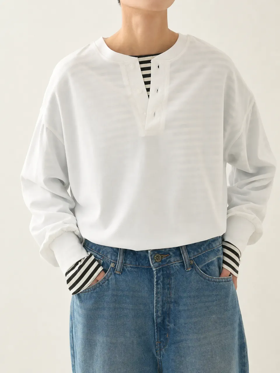 ストライプ柄インナーに重ねた白のヘンリーネック長袖Tシャツ。カジュアルウェアのサンプル参考