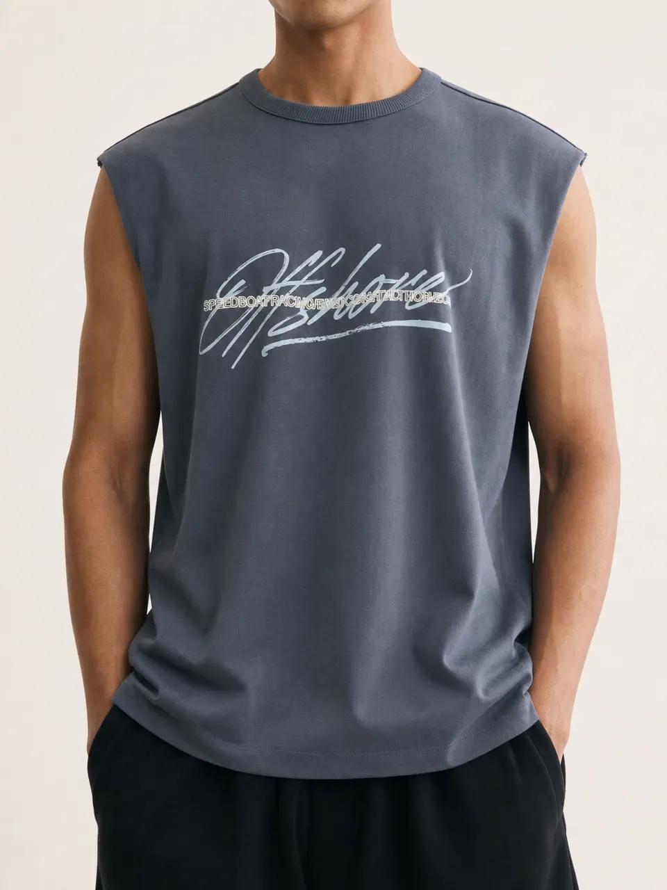 モデル着用のブルー・オーバーサイズグラフィックノースリーブTシャツ。OEMストリートウェアの参考